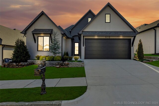 modern farmhouse style home featuring a lawn and a garage