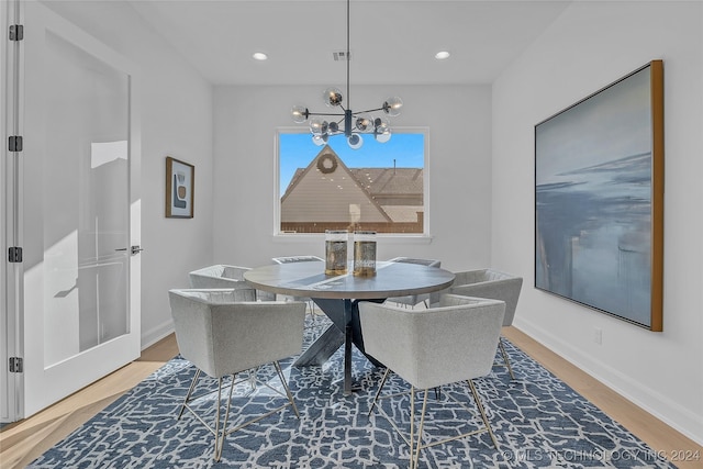 dining room with wood-type flooring and a notable chandelier