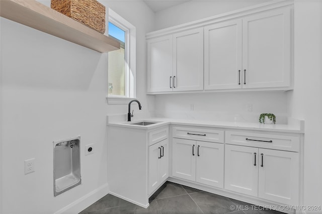 washroom featuring cabinets, hookup for an electric dryer, dark tile patterned flooring, and sink