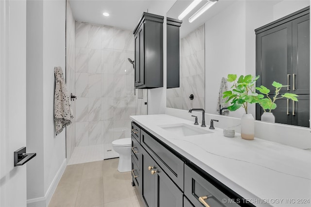 bathroom featuring vanity, toilet, tile patterned flooring, and a tile shower