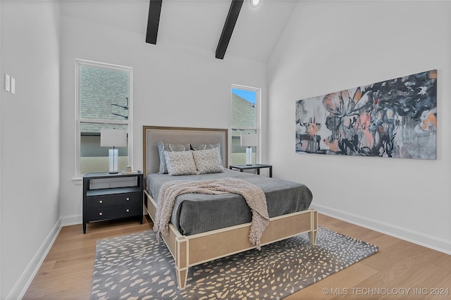 bedroom featuring wood-type flooring, high vaulted ceiling, and beamed ceiling