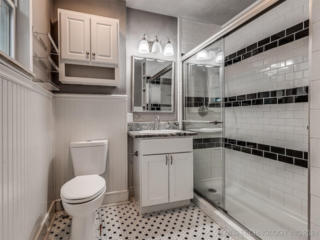 bathroom featuring tile patterned flooring, vanity, an enclosed shower, and toilet