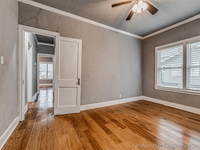 spare room featuring ceiling fan, wood-type flooring, a textured ceiling, and ornamental molding