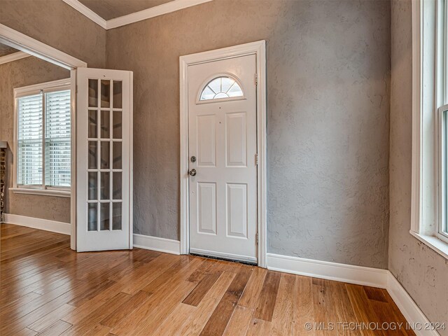 foyer entrance with a healthy amount of sunlight, light hardwood / wood-style floors, and ornamental molding