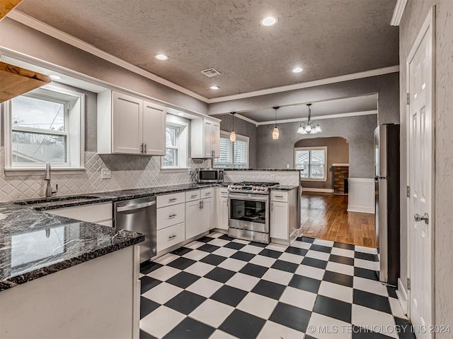 kitchen featuring white cabinets, decorative light fixtures, sink, and stainless steel appliances