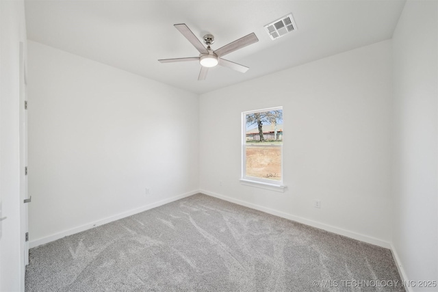 unfurnished room with baseboards, visible vents, a ceiling fan, and carpet