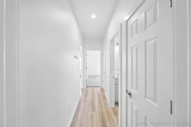 hall with light wood finished floors and baseboards