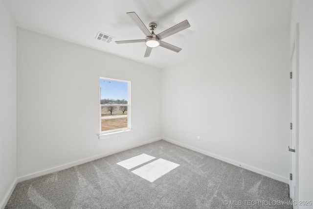 spare room with carpet, visible vents, and baseboards