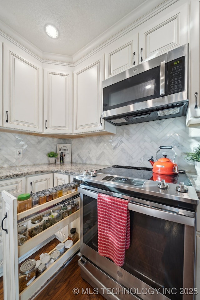 kitchen featuring backsplash, stainless steel appliances, and white cabinetry