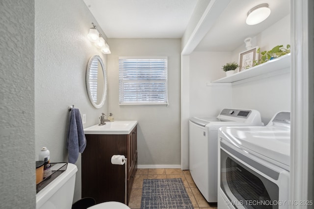 laundry area featuring sink, light tile patterned floors, and independent washer and dryer