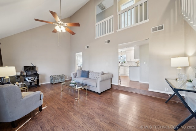 living room with dark hardwood / wood-style flooring, high vaulted ceiling, ceiling fan, and a healthy amount of sunlight