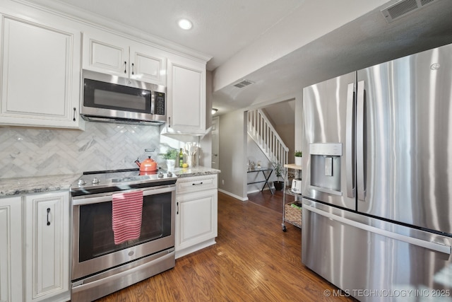 kitchen featuring decorative backsplash, light stone countertops, stainless steel appliances, dark hardwood / wood-style floors, and white cabinetry