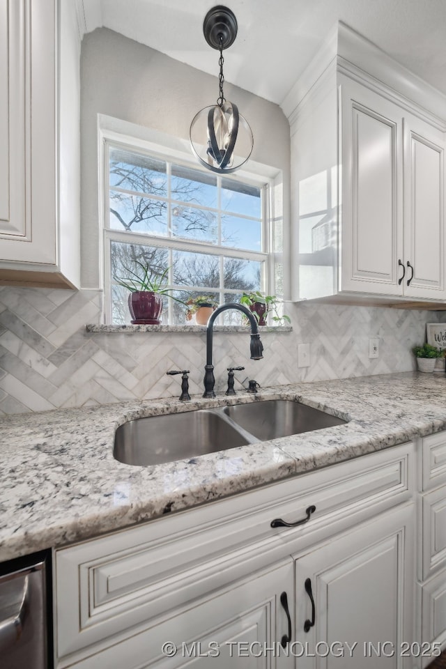 kitchen with sink, white cabinets, and decorative light fixtures