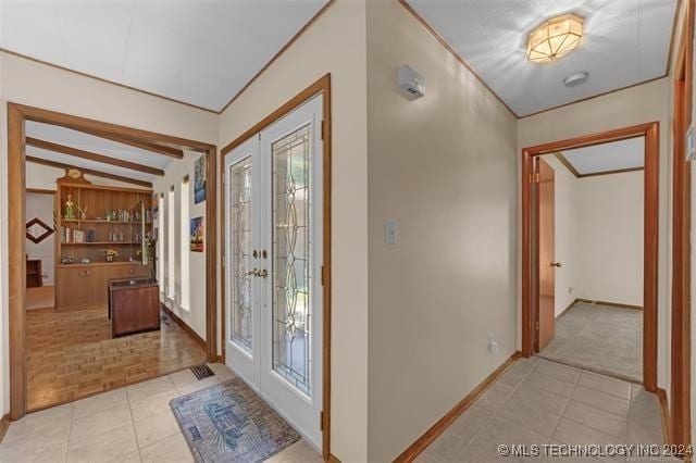 foyer entrance featuring light parquet flooring, lofted ceiling with beams, and french doors