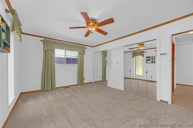 unfurnished bedroom featuring ceiling fan, light carpet, and ornamental molding