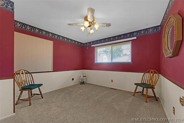 living area with ceiling fan and light colored carpet