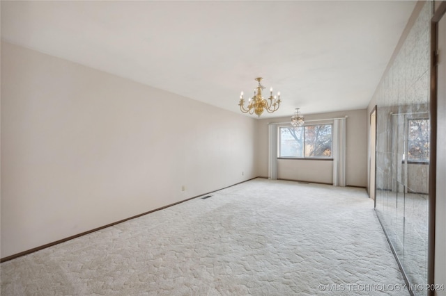 empty room with light carpet and an inviting chandelier