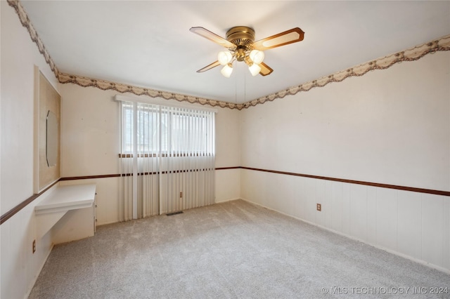 carpeted empty room featuring ceiling fan