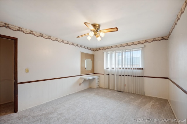 empty room featuring ceiling fan and light colored carpet