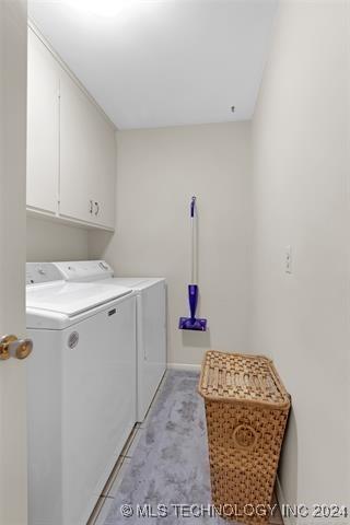 washroom with washer and dryer and cabinets