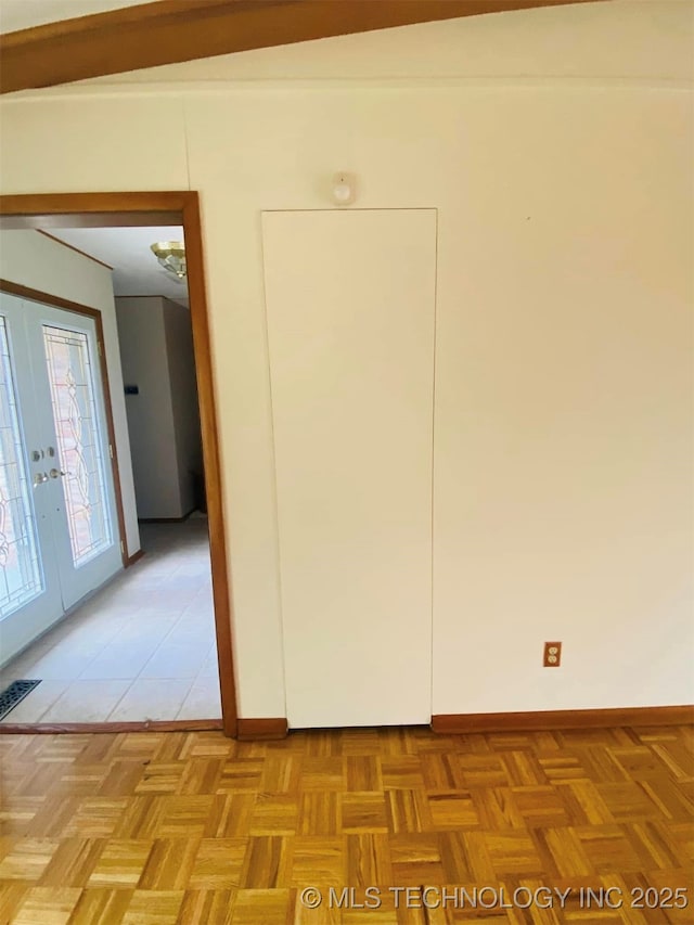 unfurnished room with light parquet flooring and french doors