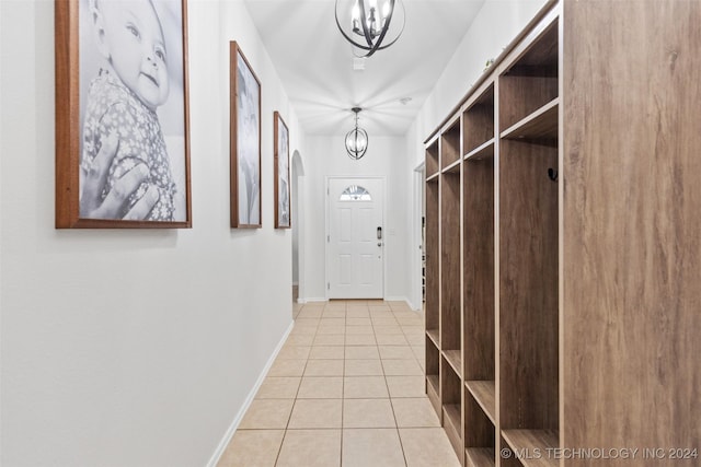 mudroom featuring a notable chandelier and light tile patterned flooring