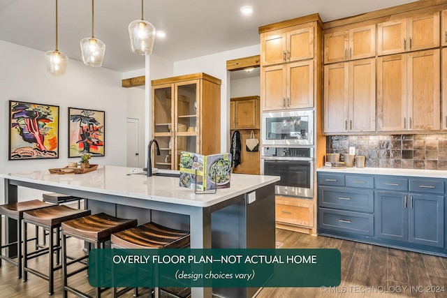 kitchen with tasteful backsplash, a breakfast bar, sink, hanging light fixtures, and stainless steel microwave