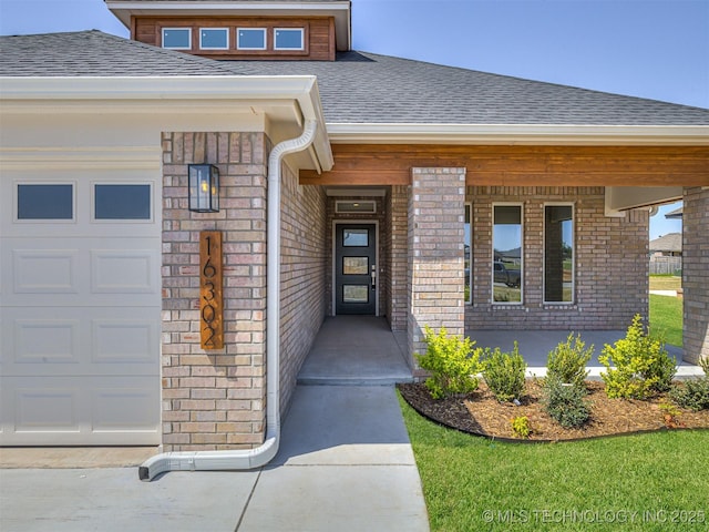 doorway to property featuring roof with shingles and a garage