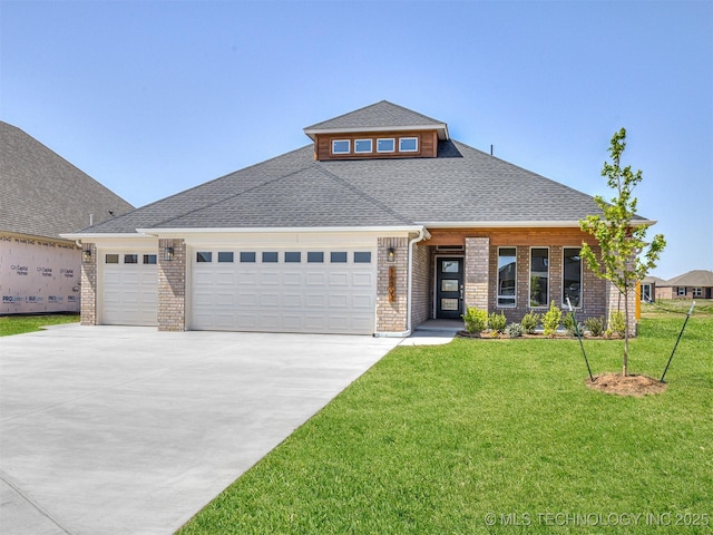 prairie-style house with roof with shingles, concrete driveway, brick siding, an attached garage, and a front yard