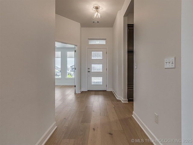 entryway featuring wood-type flooring, visible vents, and baseboards