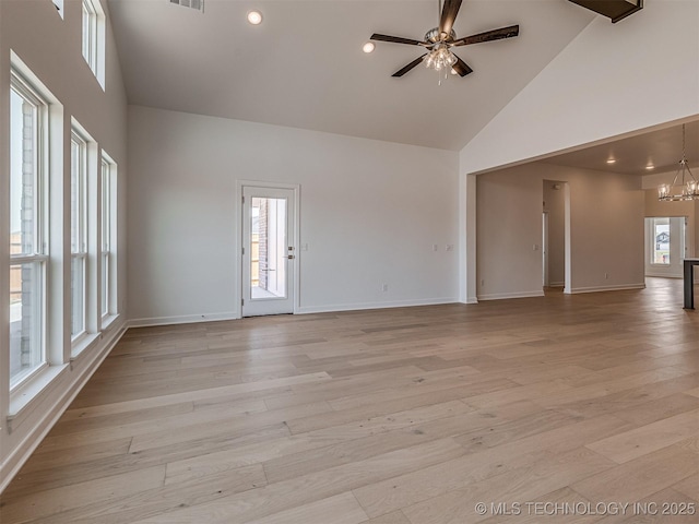 unfurnished living room featuring high vaulted ceiling, baseboards, light wood-style floors, and ceiling fan with notable chandelier
