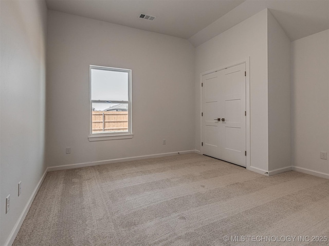 carpeted spare room featuring visible vents and baseboards