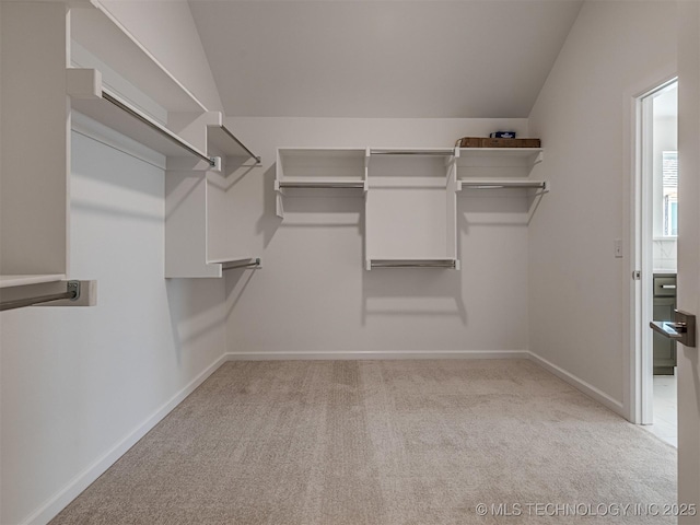 spacious closet with vaulted ceiling and light carpet