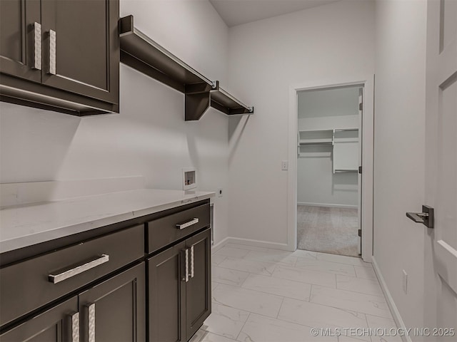 clothes washing area with marble finish floor, baseboards, cabinet space, and hookup for a washing machine