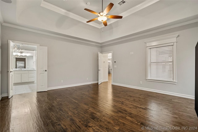 empty room featuring a high ceiling, crown molding, ceiling fan, a tray ceiling, and dark hardwood / wood-style flooring