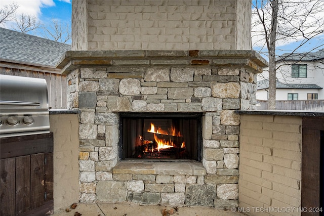 exterior details featuring an outdoor stone fireplace