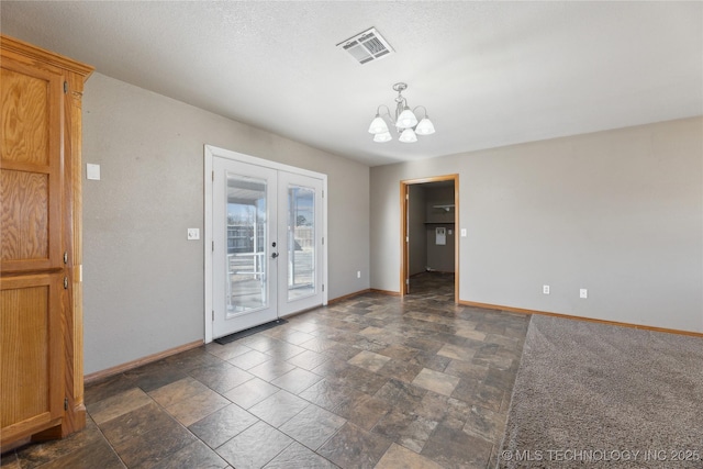 empty room with a notable chandelier and french doors