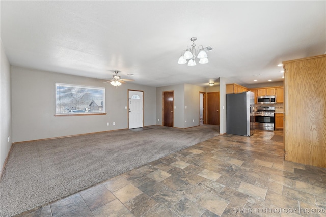 unfurnished living room featuring ceiling fan with notable chandelier and carpet