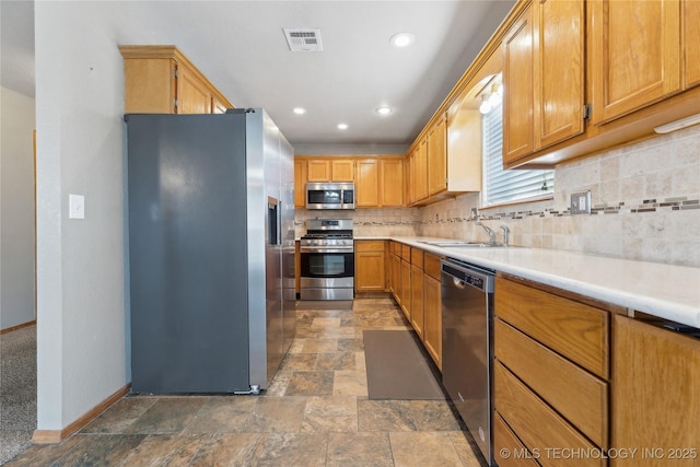 kitchen featuring stainless steel appliances, tasteful backsplash, and sink