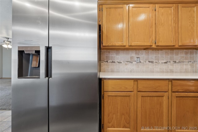 kitchen featuring ceiling fan, stainless steel fridge with ice dispenser, and decorative backsplash