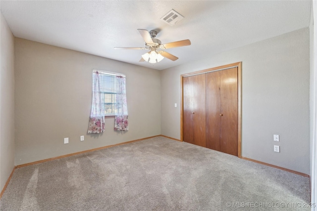 unfurnished bedroom with carpet floors, a closet, and ceiling fan