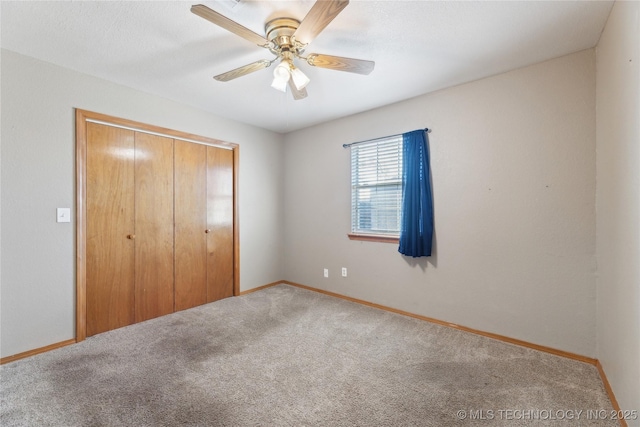 unfurnished bedroom featuring ceiling fan, carpet, and a closet