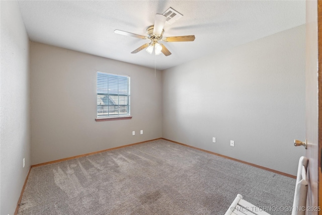 carpeted spare room with ceiling fan