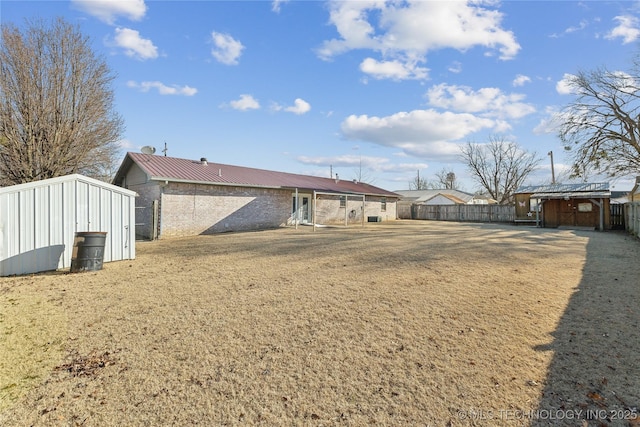 rear view of property featuring a yard and a shed