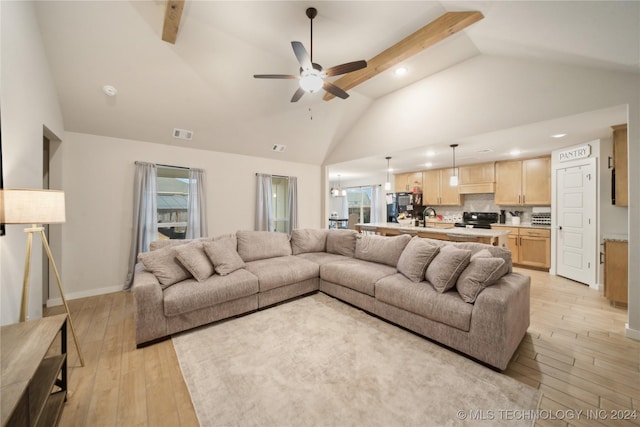 living room featuring ceiling fan, sink, lofted ceiling with beams, and light wood-type flooring