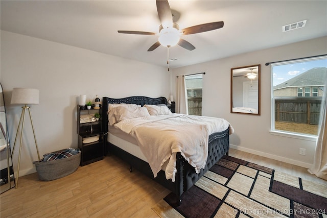 bedroom featuring multiple windows, ceiling fan, and light hardwood / wood-style floors