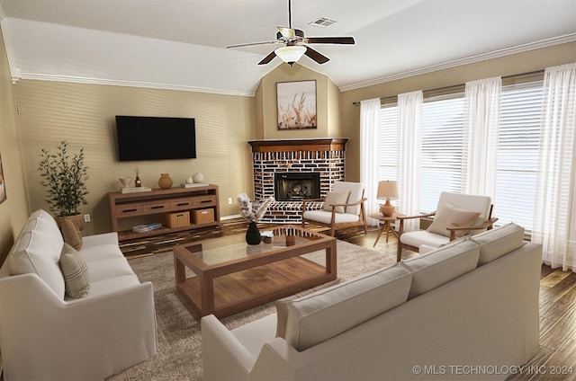 living room with ceiling fan, crown molding, hardwood / wood-style floors, vaulted ceiling, and a fireplace