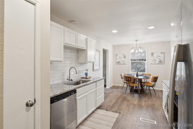 kitchen featuring white cabinets, hanging light fixtures, sink, and appliances with stainless steel finishes