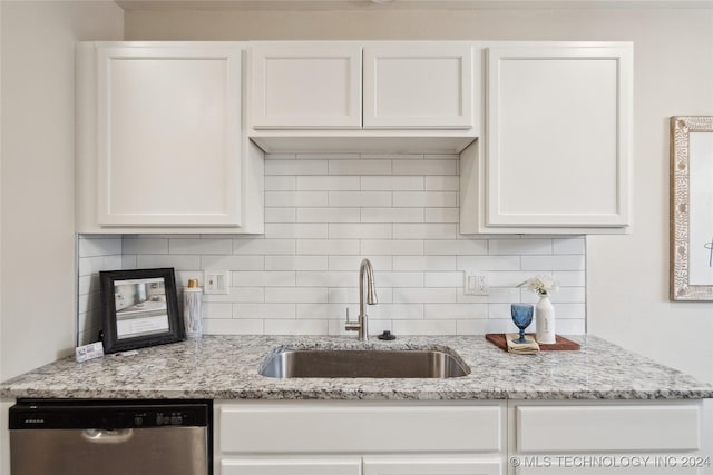 kitchen with tasteful backsplash, white cabinetry, sink, and stainless steel dishwasher