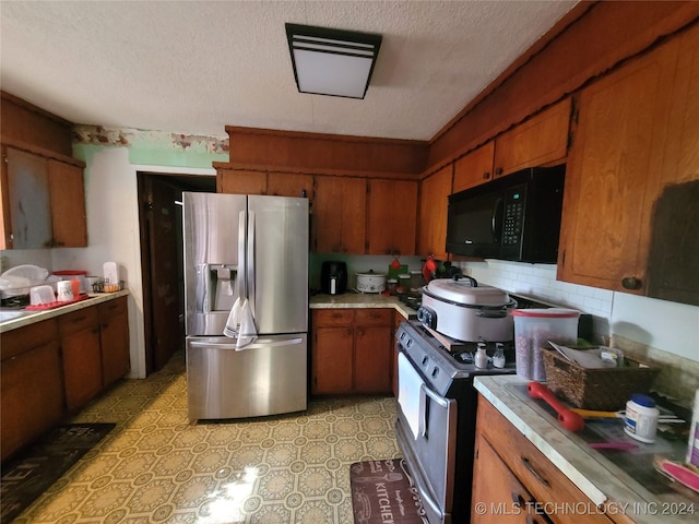 kitchen with stainless steel fridge with ice dispenser, white stove, a textured ceiling, and backsplash